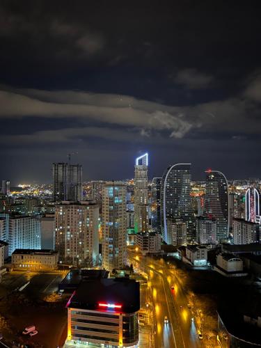 a city lit up at night with buildings and street lights at City centre Apartment in Esenyurt