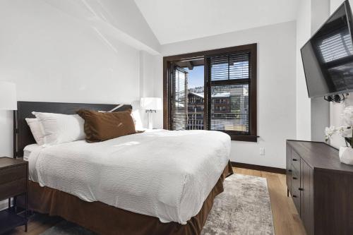 a white bedroom with a bed and a window at Capitol Peak 3518 in Snowmass Village