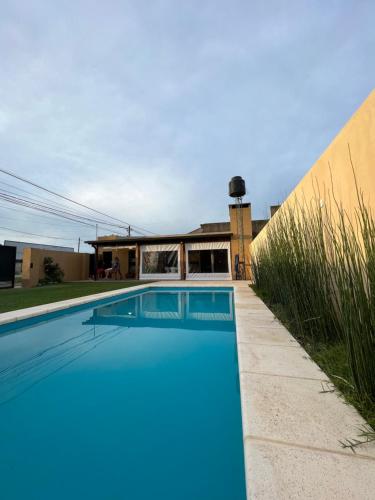 a swimming pool in front of a house at El Quincho in Lobos
