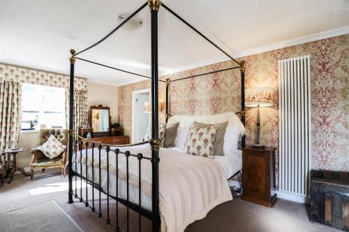 a bedroom with a four poster bed and a fireplace at The Black Swan in Ravenstonedale