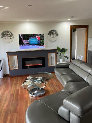 a living room with a couch and a fireplace at Palm beach Sydney, Modern home with water view in Palm Beach