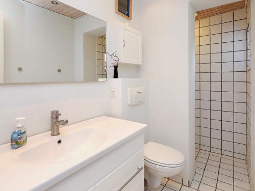 Baño blanco con lavabo y aseo en Holiday home Bindslev VI, en Bindslev