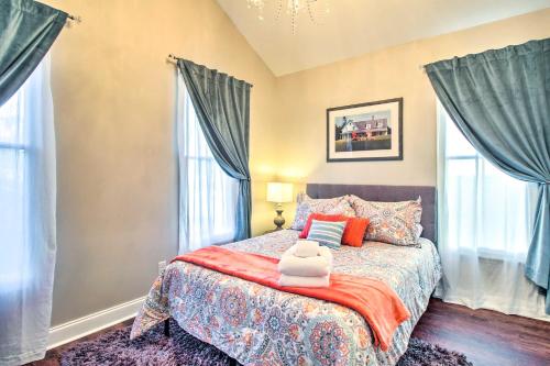 a bedroom with a large bed with blue curtains at Chic Thomas Square Home in Walkable Location! in Savannah