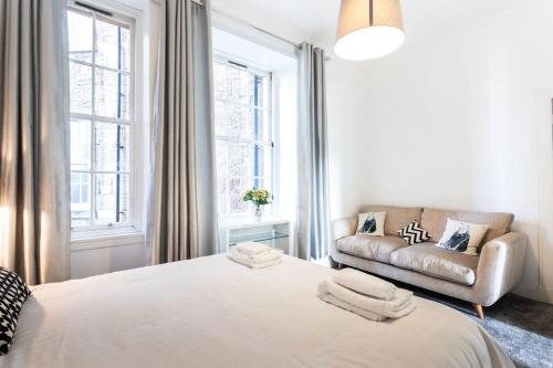 格拉斯哥GLASGOW WEST END 5 MIN WALK TO SECC AND HYDRO的白色卧室设有一张大床和一张沙发