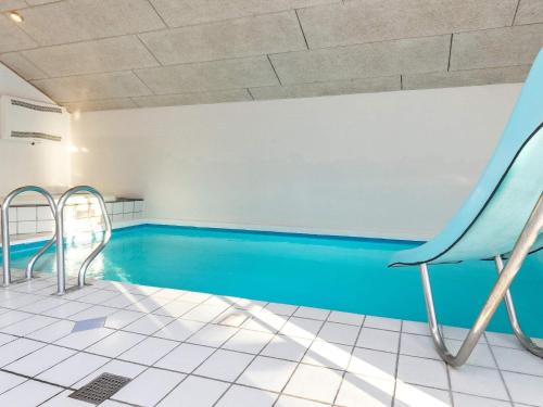 una piscina con una silla y una piscina azul en 14 person holiday home in Vejers Strand, en Vejers Strand