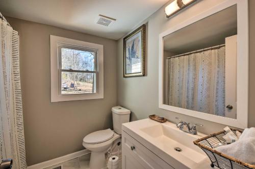a bathroom with a toilet and a sink and a mirror at Modern Commerce House Rental with Fire Pit! in Commerce
