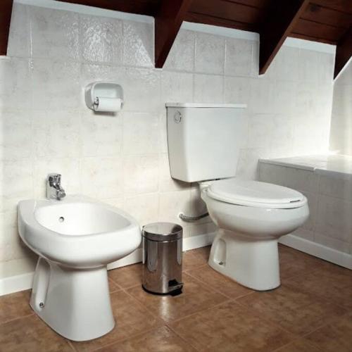 a bathroom with a toilet and a sink and a tub at Cabaña La pionera in San Carlos de Bariloche
