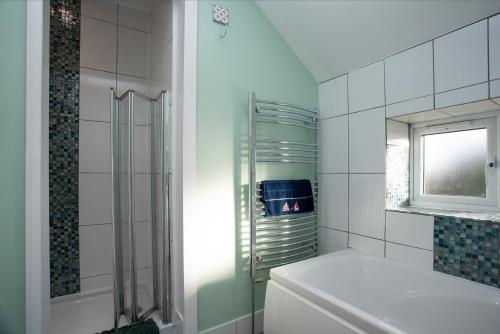 uma casa de banho com um chuveiro, um WC e uma janela. em Seymour House em Exmouth