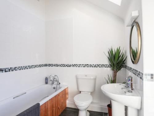 a bathroom with a tub and a toilet and a sink at Ynys Faelog Cottage in Menai Bridge
