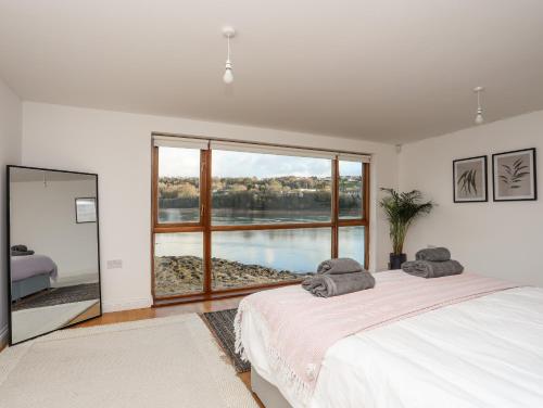 a bedroom with a bed and a large window at Ynys Faelog Cottage in Menai Bridge