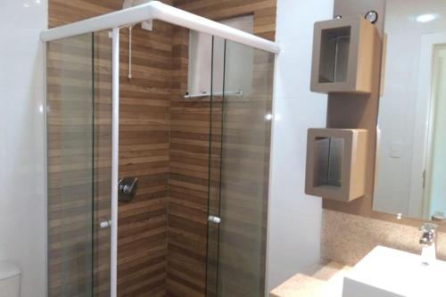 baño con ducha y puerta de cristal en Casa com spa- cod 113, en Bombinhas