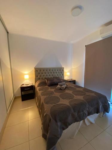 a bedroom with a large bed and two night stands at Departamento Arbo y Blanco in Resistencia