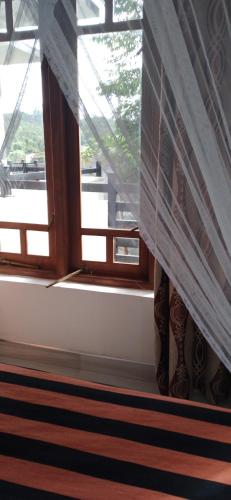 a window with a curtain in a room at Holly House Homestay in Ella