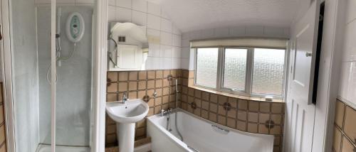 a bathroom with a sink and a tub and a toilet at Amazing and Romantic O2 Arena 4 Bedrooms House free parking in London