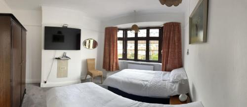 um quarto de hotel com duas camas e uma janela em Amazing and Romantic O2 Arena 4 Bedrooms House free parking em Londres