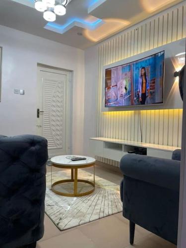 a living room with a tv and a couch and a table at Shogz Homes in Lagos