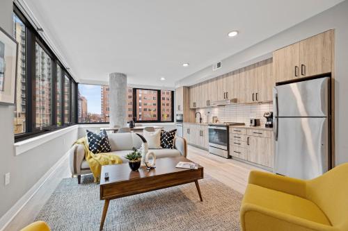 an open kitchen and living room with yellow chairs at Coda on Half, a Placemakr Experience - Navy Yard in Washington