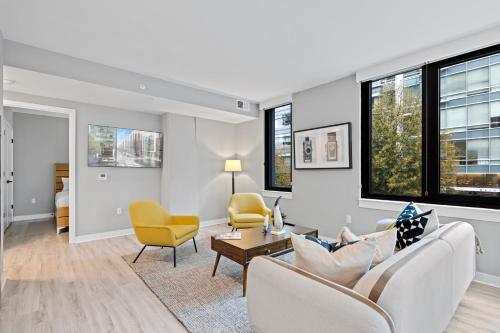a living room with a couch and chairs and windows at Coda on Half, a Placemakr Experience - Navy Yard in Washington