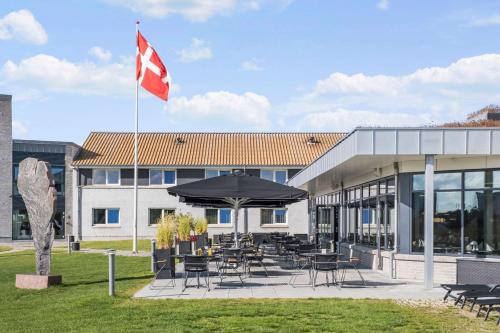 un pavillon canadien battant devant un bâtiment dans l'établissement Best Western Plus Hotel Fredericia, à Fredericia