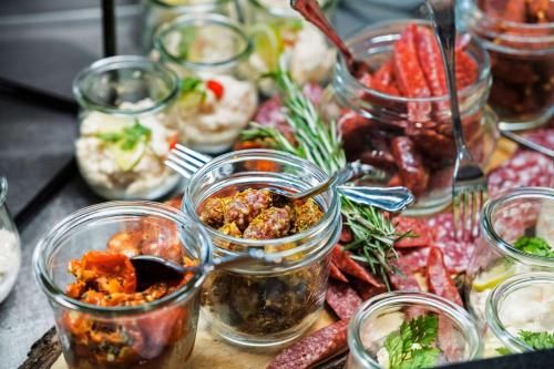 a table with many jars of food on it at Best Western Plus Hotel Fredericia in Fredericia