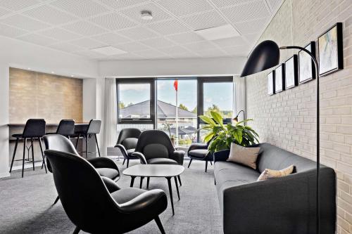 a waiting room with chairs and a couch and tables at Best Western Plus Hotel Fredericia in Fredericia