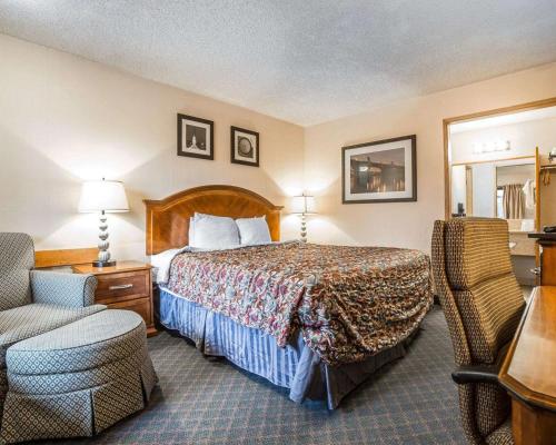 una camera d'albergo con letto e sedia di Rodeway Inn Baker City a Baker City