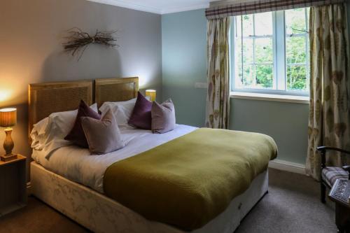 a bedroom with a bed with pillows and a window at The Black Swan in Ravenstonedale