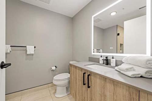 a bathroom with a sink and a toilet and a mirror at Coda on Half, a Placemakr Experience - Navy Yard in Washington