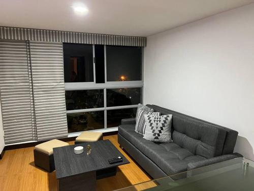 ein Wohnzimmer mit einem Sofa und einem großen Fenster in der Unterkunft Apartamento en Medellín, laureles in Medellín