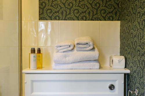a pile of towels sitting on a shelf in a bathroom at The Black Swan in Ravenstonedale