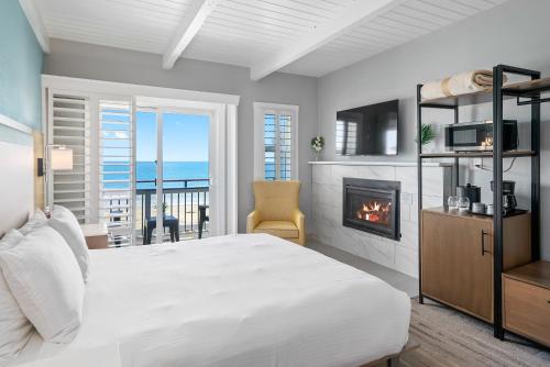 a bedroom with a bed and a fireplace at Shoreline Inn...on the beach in Cayucos