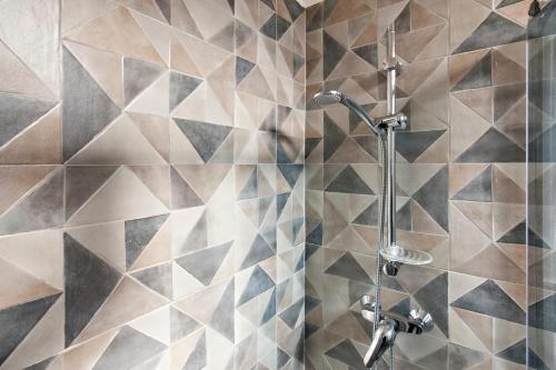 a bathroom with a shower with geometric tiles at Merabulò in Lecce