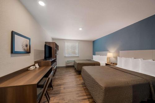 a hotel room with two beds and a flat screen tv at WoodSpring Suites Wesley Chapel-Tampa in Wesley Chapel