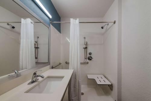 bagno bianco con lavandino e specchio di WoodSpring Suites Wesley Chapel-Tampa a Wesley Chapel