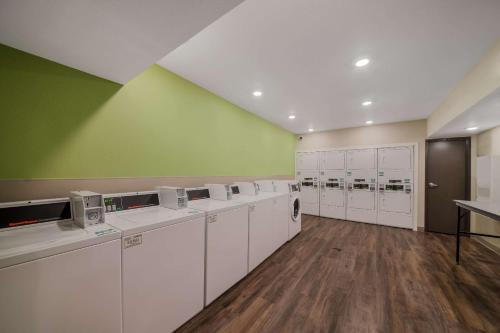 a laundry room with white washing machines and green walls at WoodSpring Suites Wesley Chapel-Tampa in Wesley Chapel