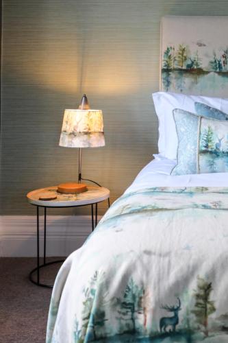a bedroom with a bed with a lamp on a table at The Black Swan in Ravenstonedale