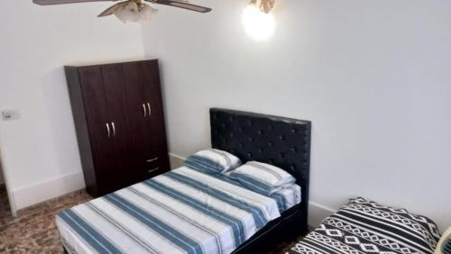ein Schlafzimmer mit einem Bett und einem Schrank in der Unterkunft Casa LA ARGENTINA in San Luis