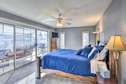 1 dormitorio con cama azul y ventana grande en Bullhead City Home with Game Room!, en Bullhead City
