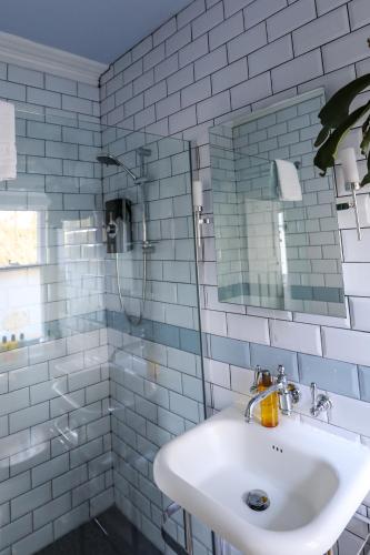 a white bathroom with a sink and a mirror at The Black Swan in Ravenstonedale