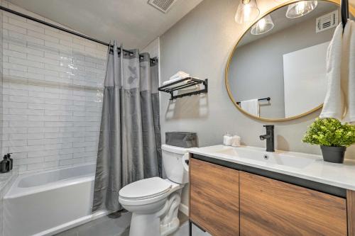 a bathroom with a toilet and a sink and a mirror at Pet-Friendly Phoenix Vacation Rental with Yard in Phoenix