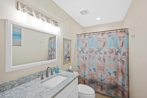 a bathroom with a sink and a shower curtain at The American Dream in Gulf Shores