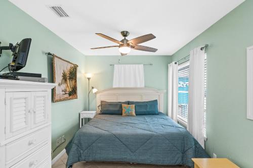 een slaapkamer met een bed en een plafondventilator bij The American Dream in Gulf Shores