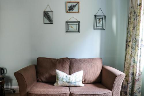 a brown couch with a pillow in a living room at The Black Swan in Ravenstonedale