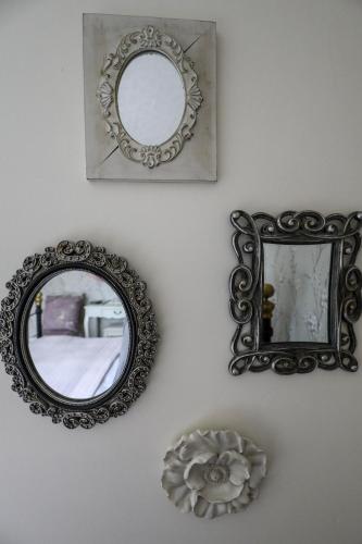 two mirrors on a wall with a flower and a bowl at The Black Swan in Ravenstonedale