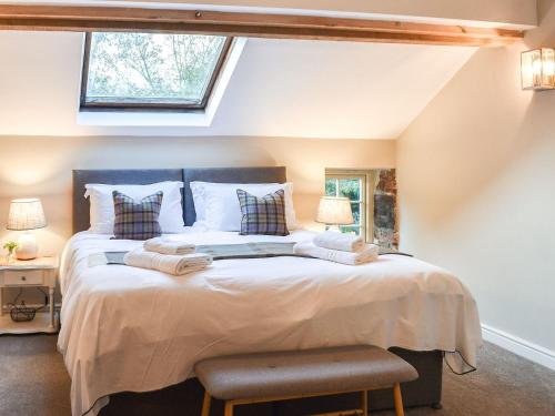 a bedroom with a large bed with two pillows at The Barn in Spofforth