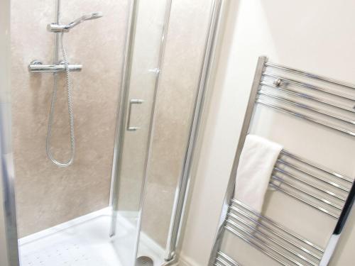 a bathroom with a shower with a glass door at The Barn in Spofforth