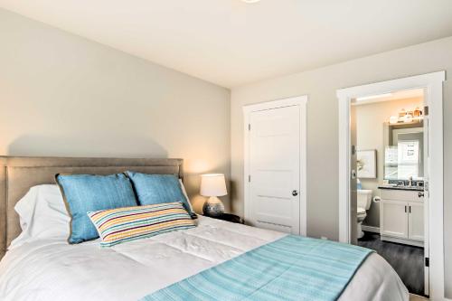 a bedroom with a large bed with blue pillows at Ocean Shores House with Hot Tub - Walk to Beach in Ocean Shores