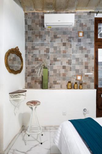 a bedroom with a white bed and a stool at Chic, Stylish 1 Bedroom Maisonette - Close to Valletta in Il-Furjana