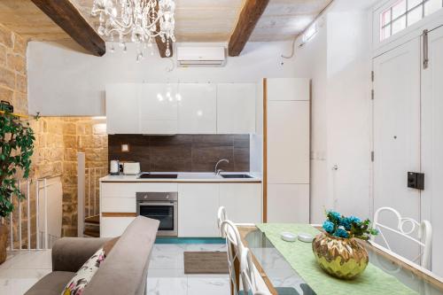 eine Küche mit einem Tisch und Stühlen im Zimmer in der Unterkunft Chic, Stylish 1 Bedroom Maisonette - Close to Valletta in Floriana
