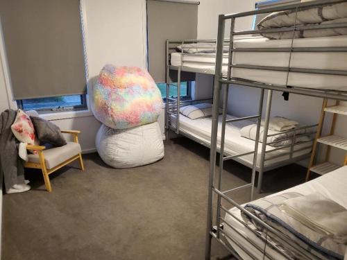 Zimmer mit Etagenbetten mit einem Stuhl und einem Kissen in der Unterkunft Torq of the Town! in Torquay